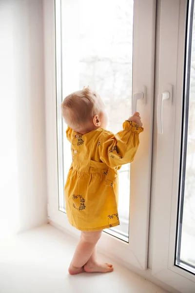 창틀에 서 있는 9 개월의 어린 소녀 . — 스톡 사진