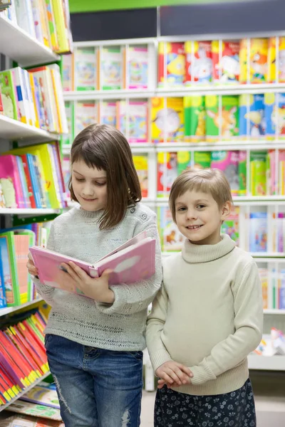 Две девочки читают книги в магазине — стоковое фото