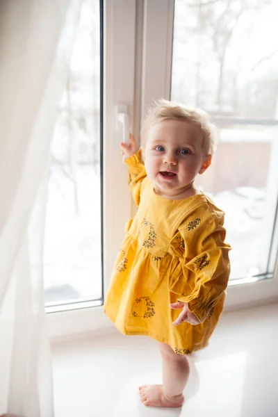 Pequeño bebé en posición peligrosa cerca de la ventana . — Foto de Stock