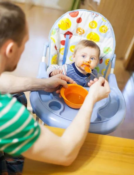 Dad giving fruit lure for baby — Stock Photo, Image