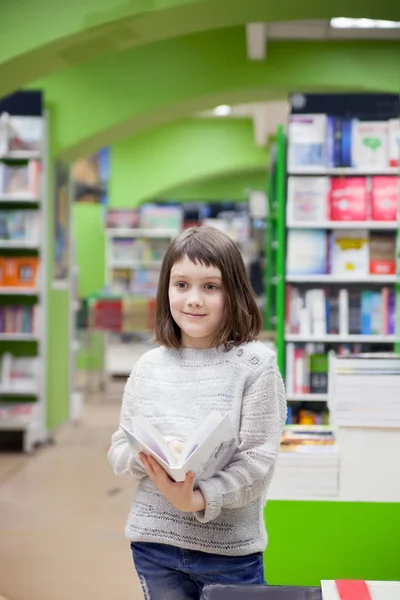 Первоклассник выбирает книги в книжном магазине — стоковое фото