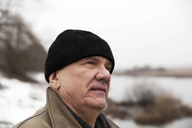 Kış arka planda şapkalı yaşlı adamın portresi. 