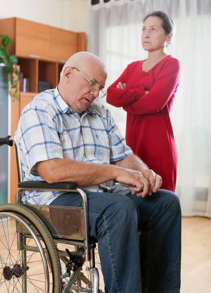 sad elderly couple of   woman and   man with   disability.