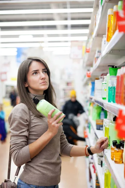 Młoda Kobieta Wybiera Produkt Pielęgnacji Skóry Sklepie — Zdjęcie stockowe