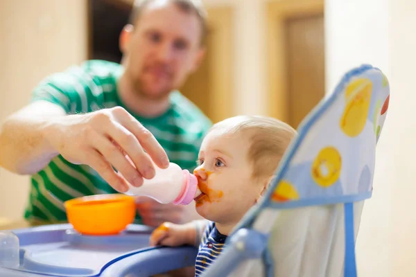 Padre Che Nutre Piccolo Bambino Con Latte Artificiale Dietro Sedia — Foto Stock