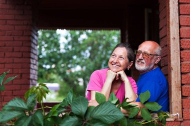  Köy kulübesinin kale kapısında olgun bir çift.