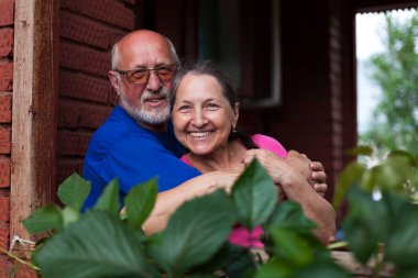  Köy kulübesinin kale kapısında olgun bir çift.