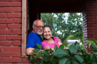  Köy kulübesinin kale kapısında olgun bir çift.