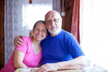 Yaşlı karı koca masada oturuyor