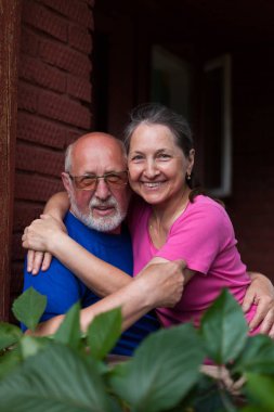  Köy kulübesinin kale kapısında olgun bir çift.