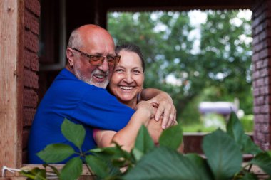  Köy kulübesinin kale kapısında olgun bir çift.