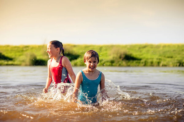 Two girls of 7 and 9 years old   swimming in   warm river.