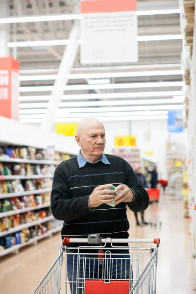 Aged man with   trolley buying groceries in   store