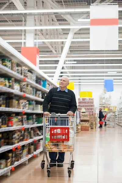 elderly man with   trolley in   supermarket