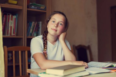 Evde ders okuyan 12 yaşındaki sevimli kız öğrenci.