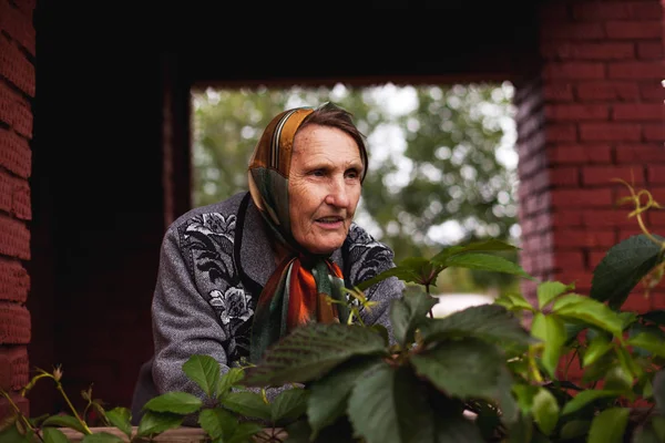 elderly woman on   porch of   country house on   autumn day.