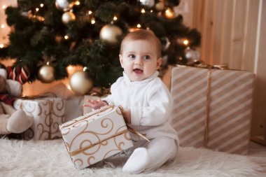 Noel ağacında hediye alan sevimli bir çocuk..