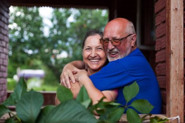 Köy kulübesinin verandasında olgun bir çift.