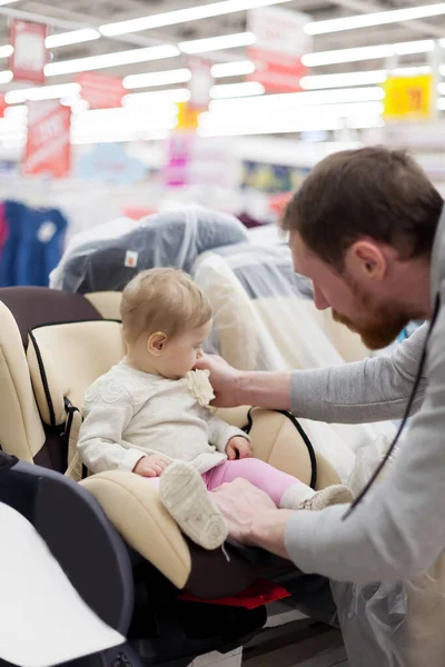 Papà con bambino in negozio acquistare seggiolino auto . — Foto Stock