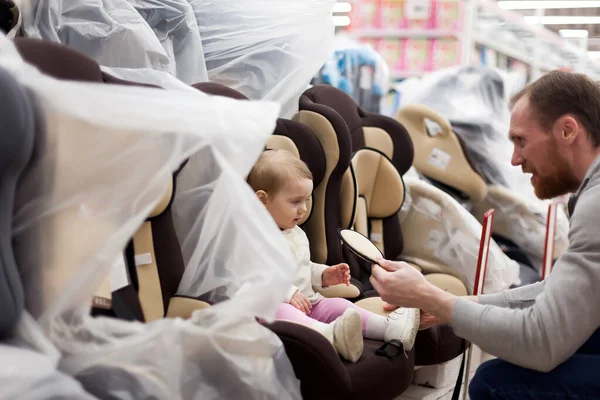 Papà con bambino in negozio acquistare seggiolino auto . — Foto Stock