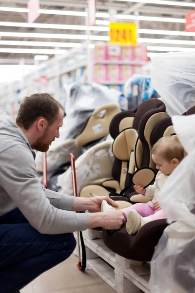 Papá con niño en la tienda comprando asiento de coche . — Foto de Stock