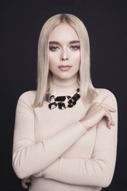 Klasik makyaj ve modern takı ile güzel genç sarışın