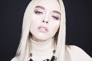 Klasik makyaj ve modern takı ile güzel genç sarışın