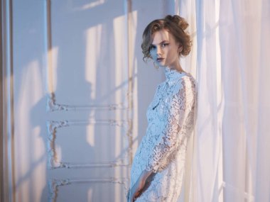Woman in lace dress at the window