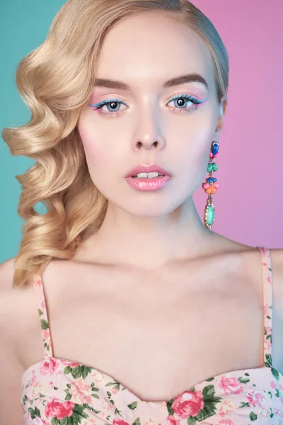 Femme blonde avec maquillage de couleur sur fond coloré — Photo