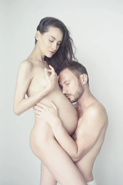 Stilig man kramar sin gravida fru — Stockfoto