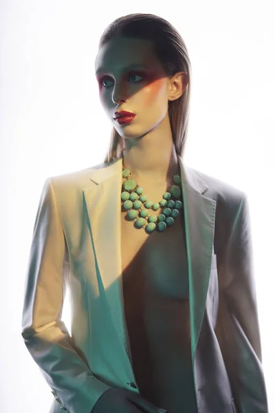Sexy dame in kleurrijke neacklace en witte jas — Stockfoto