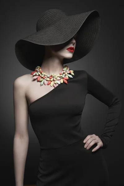 Portrait de jeune femme avec chapeau noir et robe de soirée — Photo