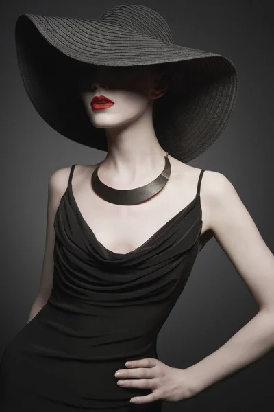 Portrait de jeune femme avec chapeau noir et robe de soirée — Photo