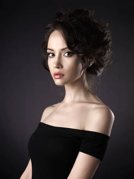 Mulher bonita com penteado elegante no fundo preto — Fotografia de Stock