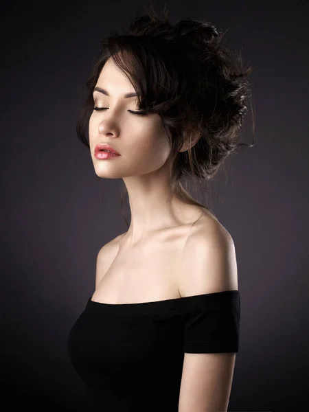 Piękna kobieta z elegancką fryzurą na czarnym tle — Zdjęcie stockowe