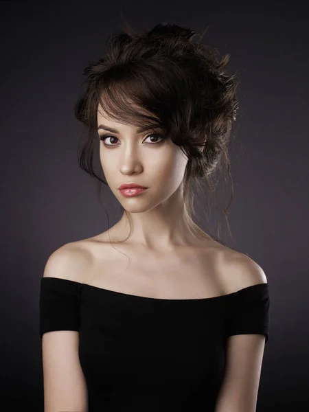 Hermosa mujer con peinado elegante sobre fondo negro —  Fotos de Stock