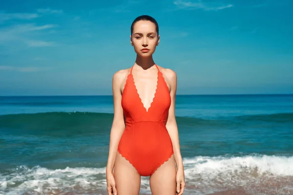 Schöne sexy Frau in roter Badebekleidung am Strand — Stockfoto