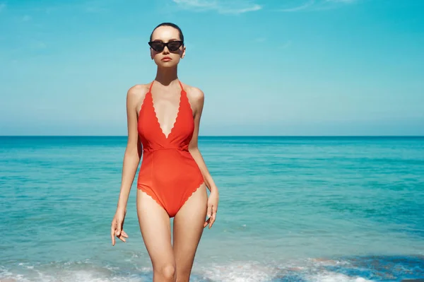 Femeie sexy în ochelari de soare frumoși și costume de baie roșii pe plajă — Fotografie, imagine de stoc