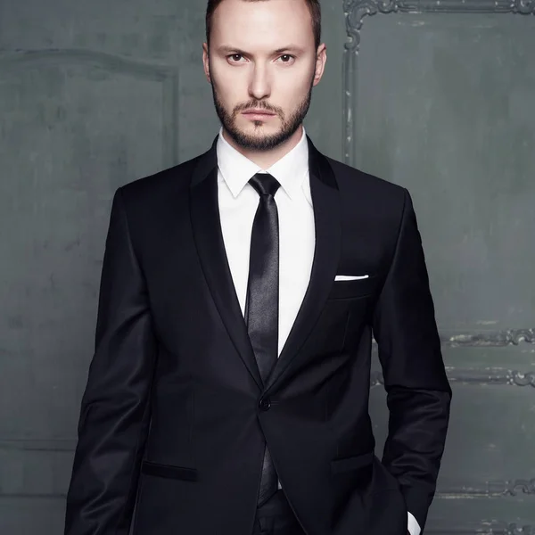 Portrait of handsome stylish man in elegant black suit Stock Photo