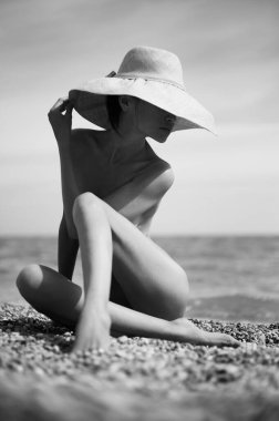 Denizde ince, güzel bir esmer. Genç ve seksi bayanın yaz seyahati fotoğrafları. Kumsalda güneşli bir gün. 