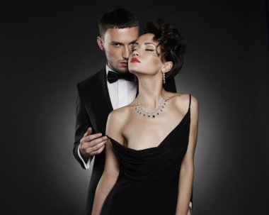 Güzel çıplak bir kadın ve takım elbiseli bir adamın şık bir fotoğrafı. Güzel kadın şık bir erkek arkadaşla poz veriyor. Seksi iki sevgili.