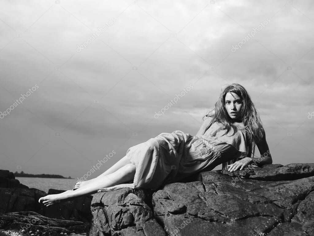 Outdoor lifestyle portrait of beautiful young blonde woman on the beach. Natural beauty. Lady in dress
