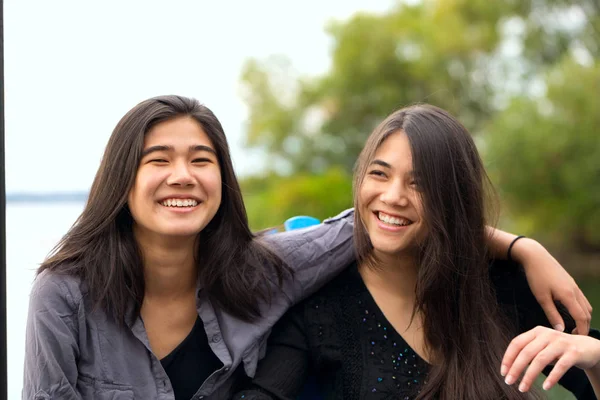 Two Biracial Sisters Asian Caucasian Teen Girls Outdoors Smiling Lake — Stock Photo, Image