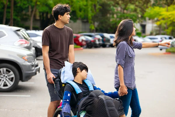 Ältere Geschwister Schieben Behinderten Kleinen Jungen Rollstuhl Über Parkplatz — Stockfoto