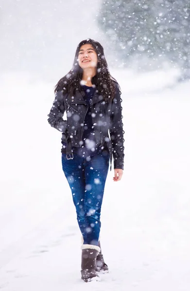 Tiener meisje wandelen langs de straat in de sneeuwstorm — Stockfoto