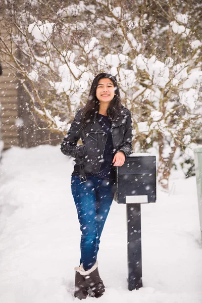 微笑的少女在冬天降雪靠在邮箱 — 图库照片