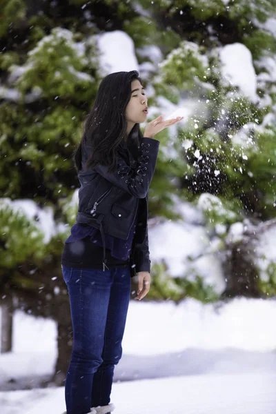 Teen flicka utomhus på vintern blåser snö av hand — Stockfoto