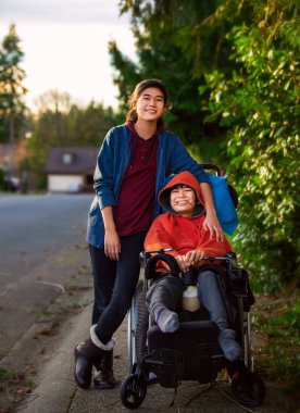 Sister standing next to disabled little brother in wheelchair ou clipart
