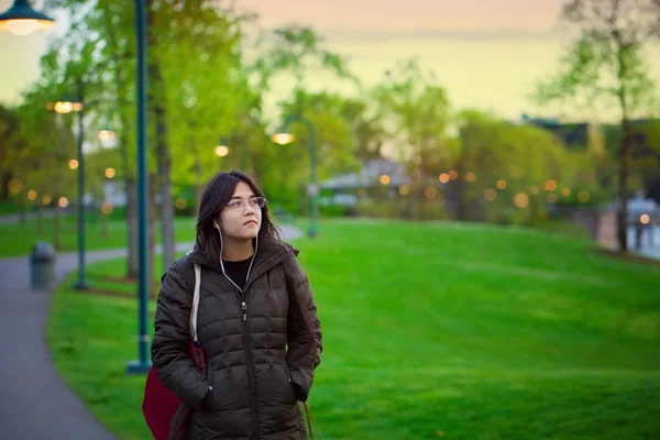 Jonge biracial vrouw loopt alleen op Lake Park in de schemering — Stockfoto