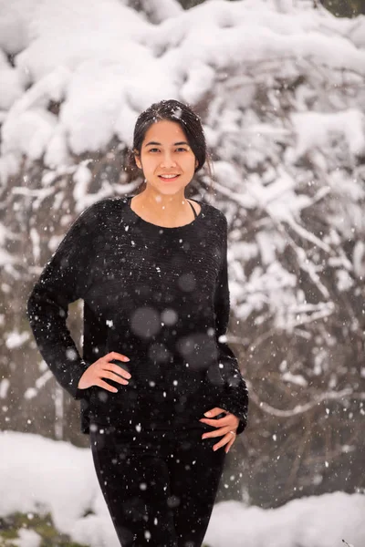 Biracial adolescente menina ao ar livre no inverno curtindo snowfall — Fotografia de Stock